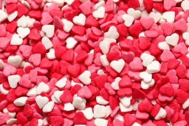 Sweet candy hearts as background, top view