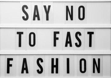 Lightbox with phrase SAY NO TO FAST FASHION as background, top view