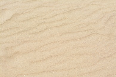 Dry beach sand with wave pattern as background