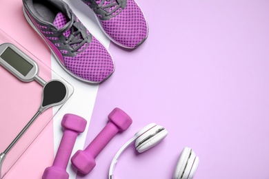 Headphones, dumbbells, floor scale and shoes on pink background, flat lay. Space for text