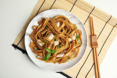 Tasty buckwheat noodles with meat served on white table, flat lay