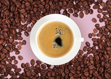 Image of Cup of tasty espresso and roasted coffee beans on pink background, flat lay