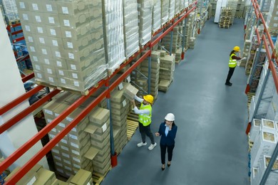 Manager and workers at warehouse, above view. Logistics center