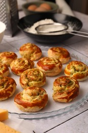 Photo of Fresh delicious puff pastry with tasty filling on white tiled surface, closeup