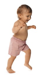 Photo of Cute baby in shorts learning to walk on white background