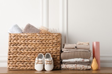 Photo of Baby clothes, shoes and accessories on wooden table