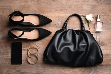 Flat lay composition with stylish shoes, woman's bag and smartphone on wooden background
