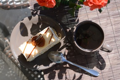 Tasty dessert, cup of fresh aromatic coffee and flowers on glass table outdoors, flat lay