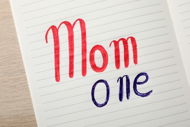 Being single mother concept. Notepad with text Mom One on white wooden table, top view