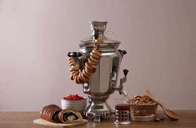 Traditional Russian samovar with treats on wooden table