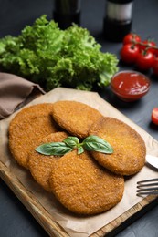 Delicious fried breaded cutlets served on black table, closeup