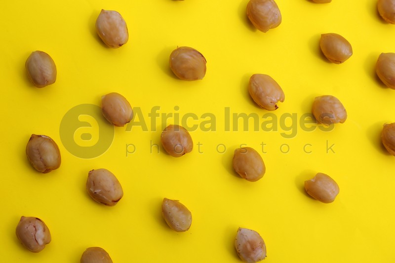 Photo of Tasty organic hazelnuts on yellow background, flat lay