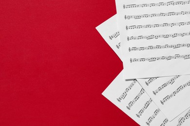 Photo of Note sheets on red background, flat lay. Space for text