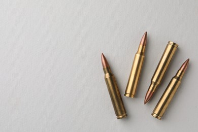 Brass bullets on white background, flat lay. Space for text
