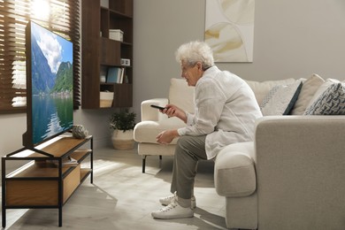 Elderly woman with poor posture watching TV in living room