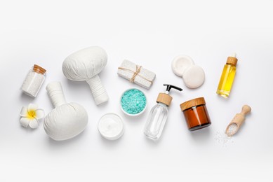 Beautiful spa composition with herbal massage bags and different care products on white background, flat lay