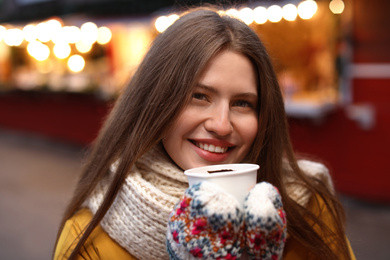 Happy woman with mulled wine at winter fair