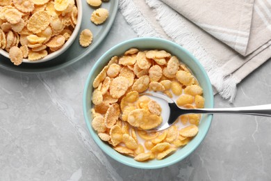 Tasty cornflakes with milk served on light grey table, flat lay