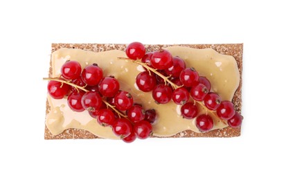 Photo of Fresh crunchy rye crispbread with peanut butter and red currant isolated on white, top view