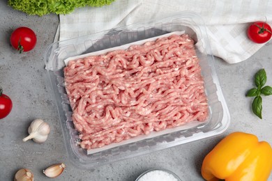 Raw chicken minced meat and ingredients on grey table, flat lay