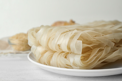 Raw rice noodles on white wooden table, closeup