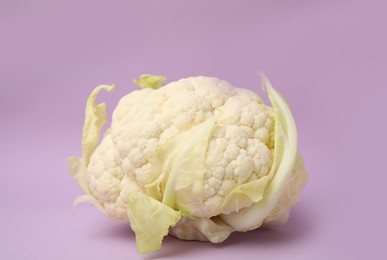 Photo of Whole fresh raw cauliflower on violet background