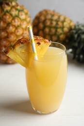 Photo of Delicious fresh pineapple juice on white wooden table