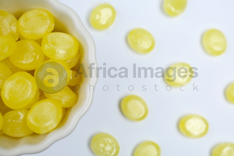 Flat lay composition with tasty lemon drops on white background
