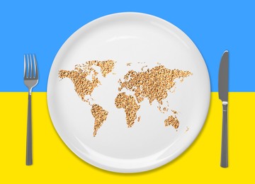 Global food crisis concept. World map made of wheat grains in plate and cutlery on background in colors of Ukrainian flag, flat lay