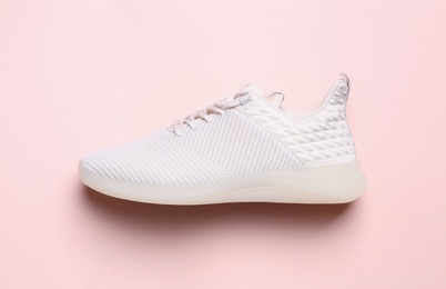 Stylish sporty sneaker on pink background, top view