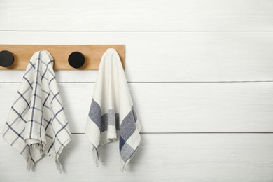 Photo of Clean kitchen towels hanging on rack. Space for text