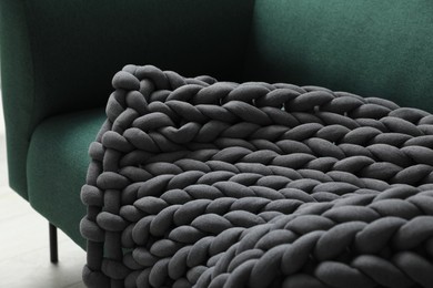 Photo of Soft chunky knit blanket on sofa indoors, closeup