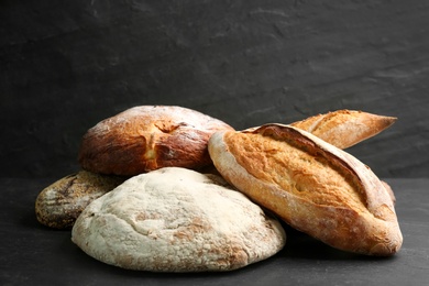 Different kinds of fresh bread on black table