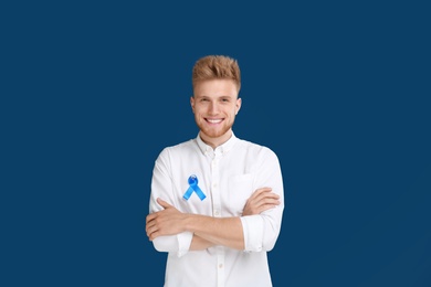 Photo of Young man with ribbon on blue background. Urology cancer awareness