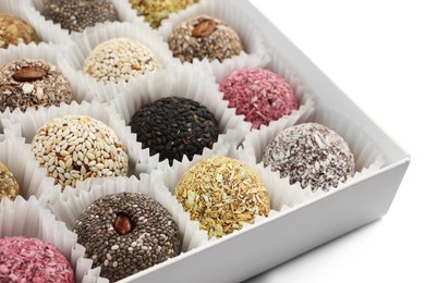 Different delicious vegan candy balls in box on white background, closeup