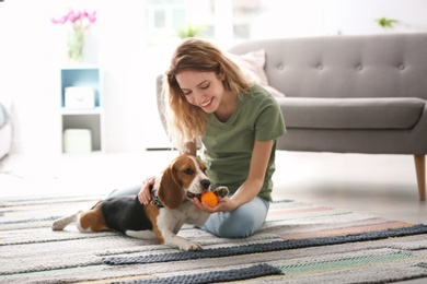 Young woman playing with her dog at home