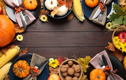 Table setting with autumn vegetables and fruits on wooden background, flat lay. Thanksgiving day celebration