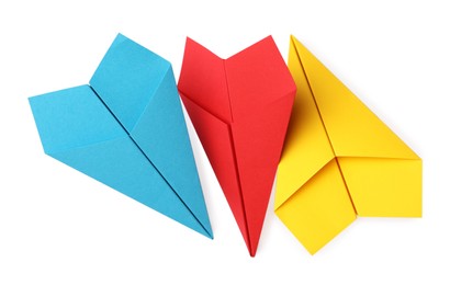 Handmade yellow, light blue and red paper planes isolated on white, top view