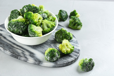 Frozen broccoli florets on light grey table. Vegetable preservation