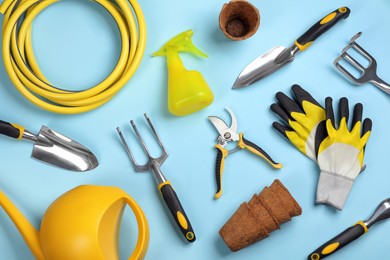 Flat lay composition with gardening tools on light blue background