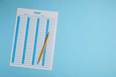 Photo of Answer sheet and pencil on light blue background, top view with space for text. Student passing exam