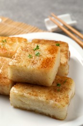 Ceramic plate with delicious turnip cake on table, closeup