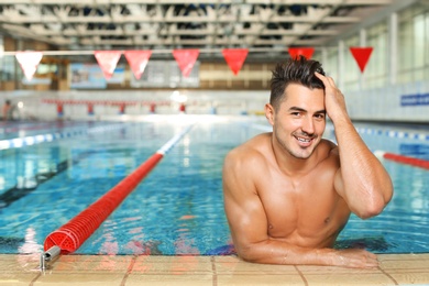 Photo of Young athletic man in swimming pool indoors
