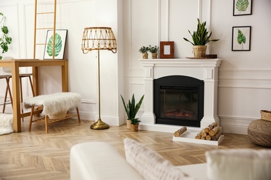Photo of Elegant artificial fireplace in room. Interior design