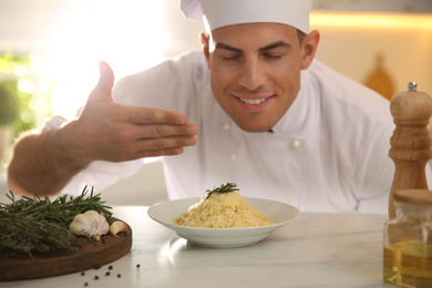 Professional chef cooking at table in kitchen, focus on dish