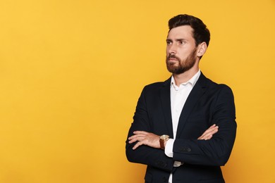Portrait of bearded man in suit on orange background. Space for text