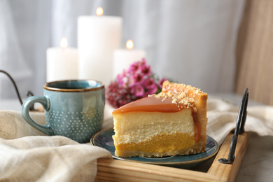 Cup of tea and delicious cheesecake on grey table, closeup