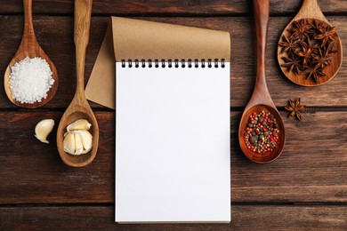Notebook and different spices on wooden table, flat lay with space for text. Cooking Classes