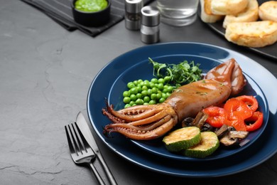 Photo of Delicious grilled squid served on black table, space for text