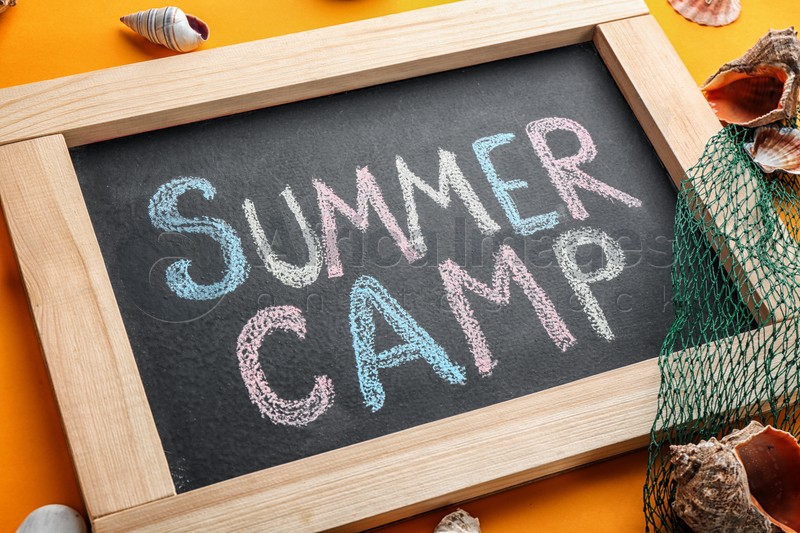 Text "SUMMER CAMP" on chalkboard and shells, closeup